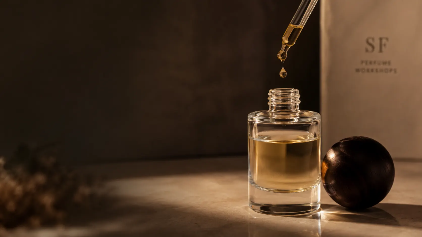 Hand dropping liquid into a perfume bottle